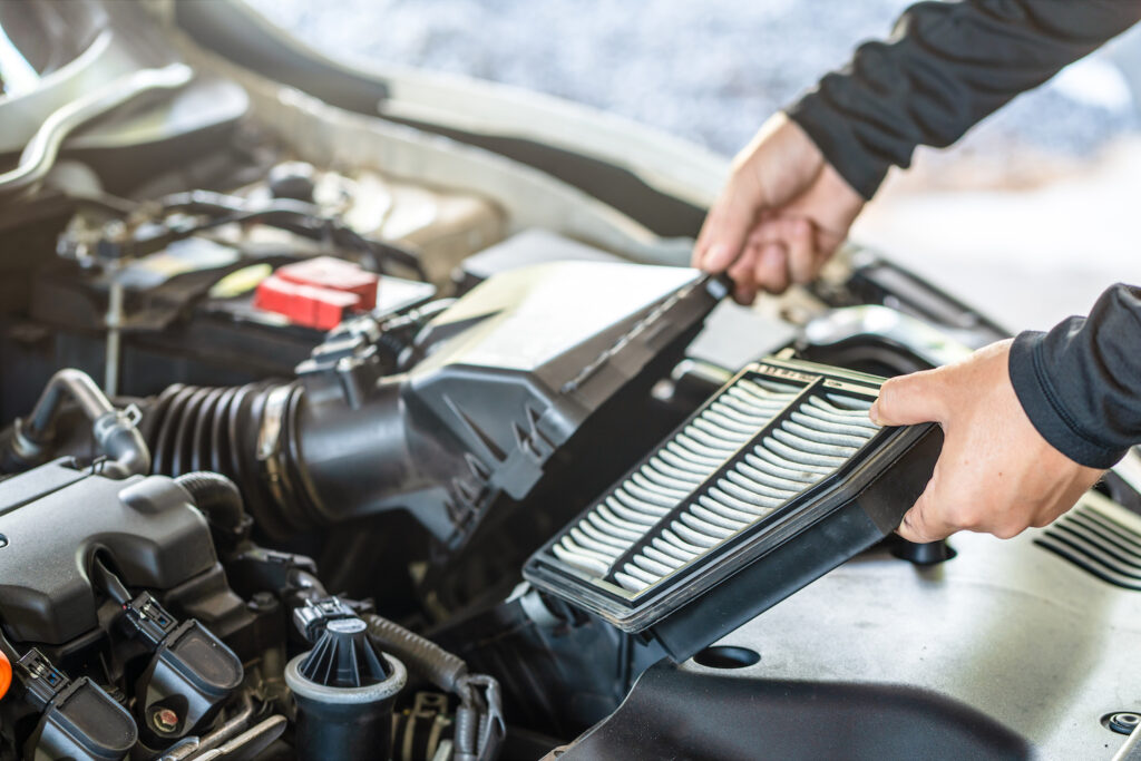 Hand des Mechanikers entfernt Luftfilter des Motors, Inspektion und Wartung des Autoservice