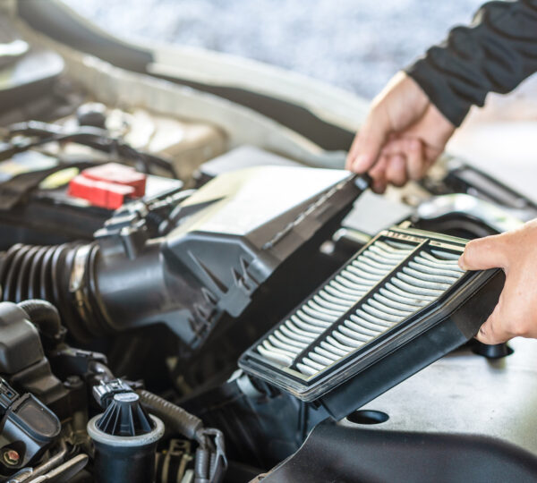 Hand des Mechanikers entfernt Luftfilter des Motors, Inspektion und Wartung des Autoservice